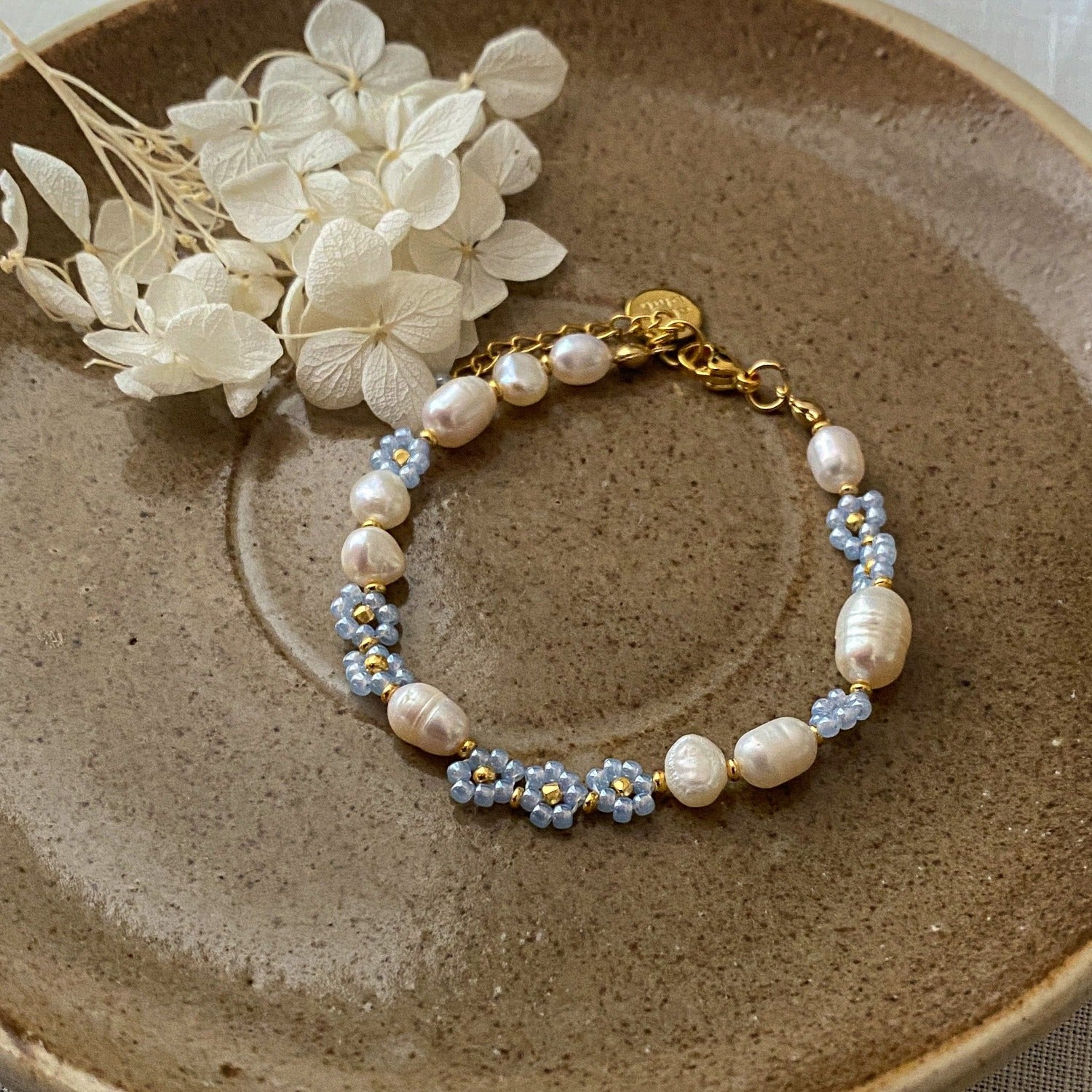 Pearl bracelet with blue flowers and golden clasps