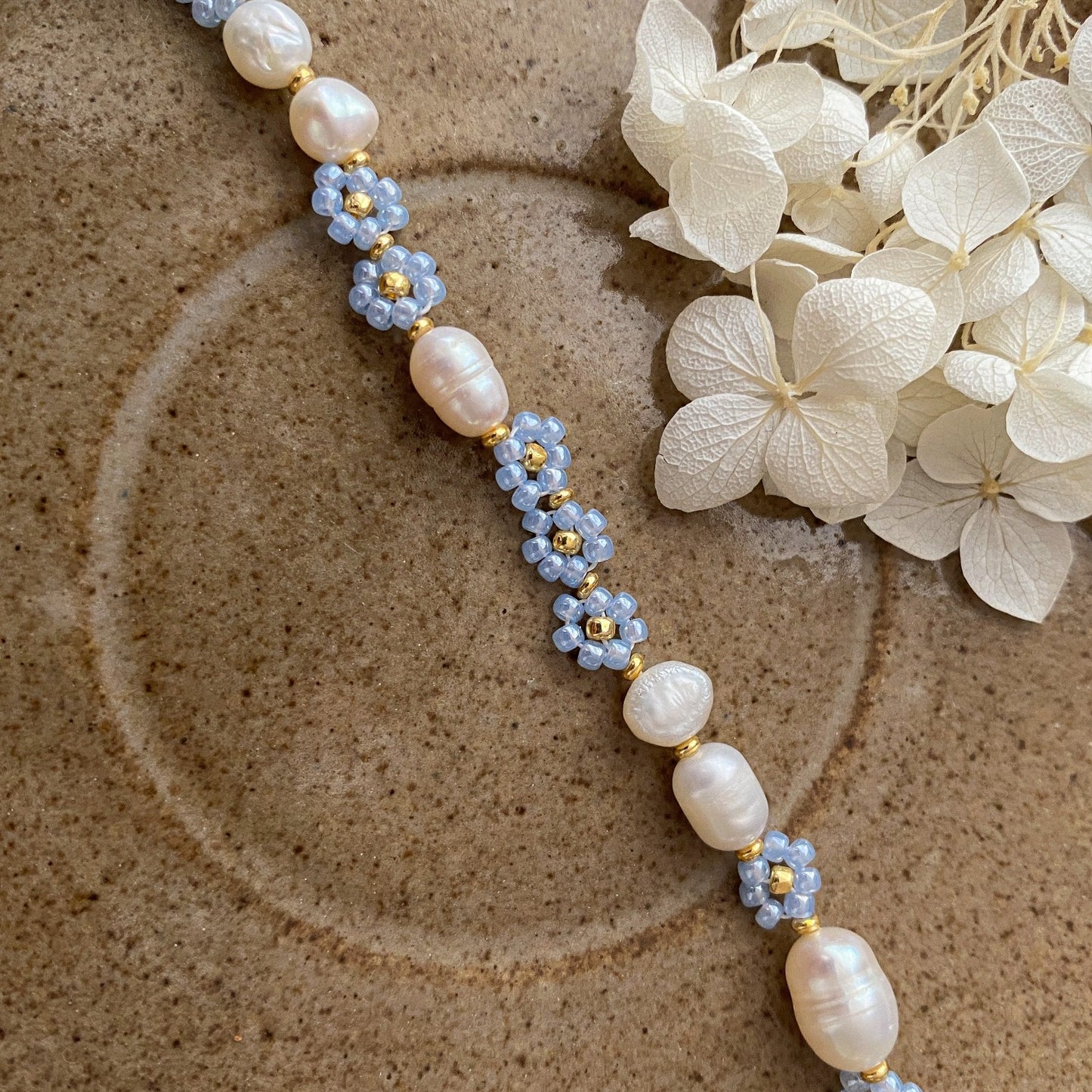 Pearl bracelet with blue flowers